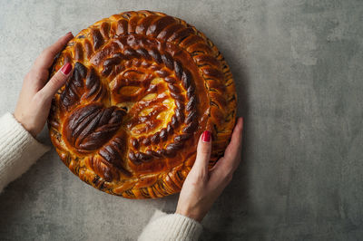 Cropped hands of woman holding baked dessert