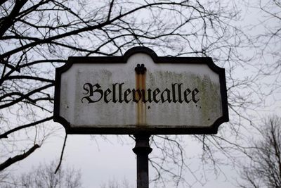 Low angle view of sign board against sky