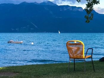 Scenic view of sea  against sky with a chair