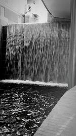 Water fountain in swimming pool against building