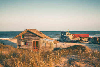 Huts at beach against clear sky