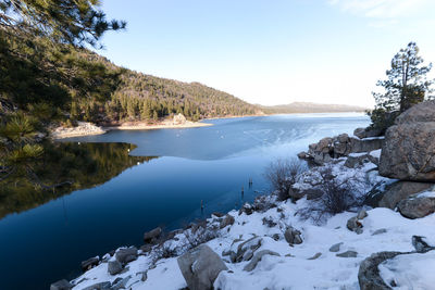 Snow on rocks by big bear lake against sky