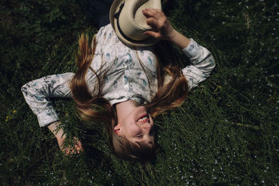 High angle view of happy woman lying on field