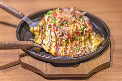 Japanese okonomiyaki covered with katsuobushi leek mayonnaise and bulldog sauce 