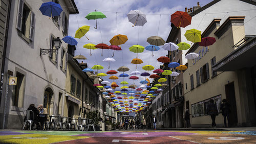 People walking on alley amidst buildings in city