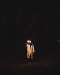 People standing on field at night