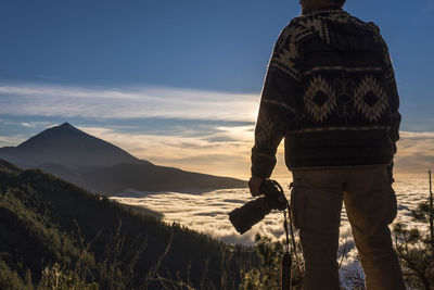 Rear view of man standing on mountain