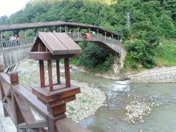 Footbridge over river amidst trees in forest