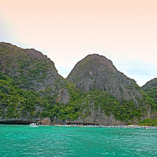 mountain, water, waterfront, sea, scenics, tranquil scene, mountain range, tranquility, beauty in nature, nature, sky, idyllic, nautical vessel, cliff, tree, non-urban scene, lake, blue, rock formation, rippled