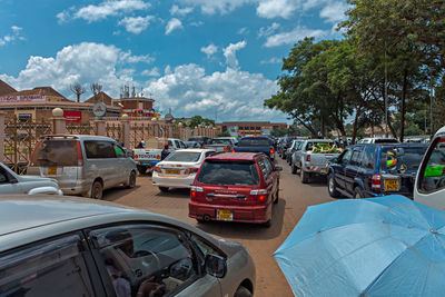 Cars on road in city against sky