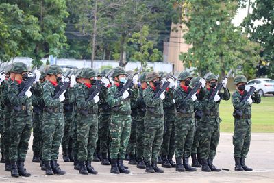 Rear view of soldiers standing on field