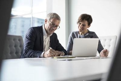 Businessman and businesswoman working together in office