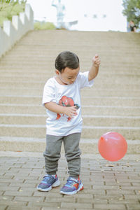 Full length of boy standing on footpath