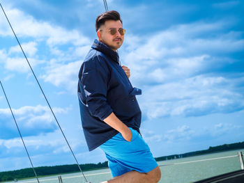 Pretty person standing on a sailing boat during his summer sailing voyage