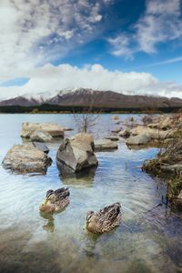 View of rocks in lake against sky