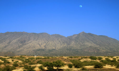 Scenic view of mountains against clear blue sky