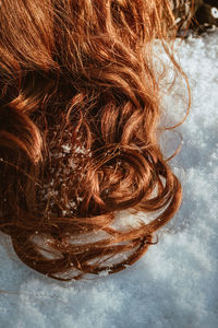 High angle view of female red hair on snow