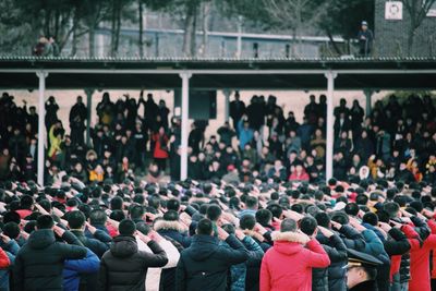 Crowd saluting outdoors