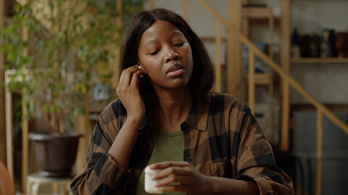 Portrait of young woman sitting at home