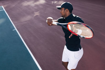 Midsection of man playing tennis