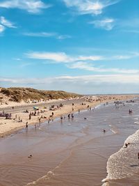 Group of people on beach against sky