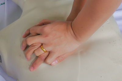 Cropped hands of paramedic practicing cpr on mannequin