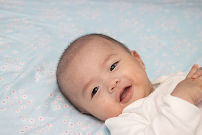 Portrait of cute baby lying on bed