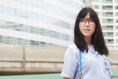 Young female doctor standing in city