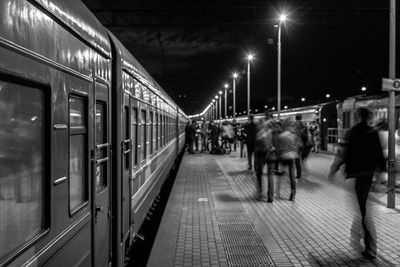 People at illuminated railroad station