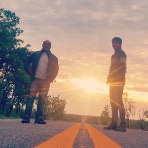 Friends standing on tree against sky during sunset