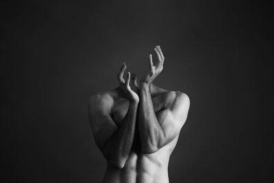 Decapitated shirtless man against gray background