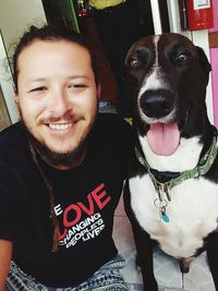 Portrait of woman with dog sitting at home