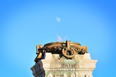 Low angle view of sculpture against clear blue sky