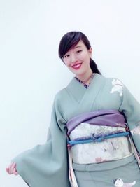 Portrait of smiling young woman against white background