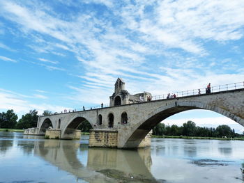 Arch bridge over river against sky