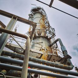 Low angle view of industry against sky