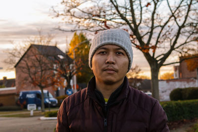 Portrait of mid adult man standing against tree