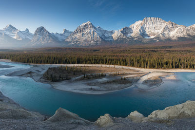 Scenic view of lake and mountains against blue sky