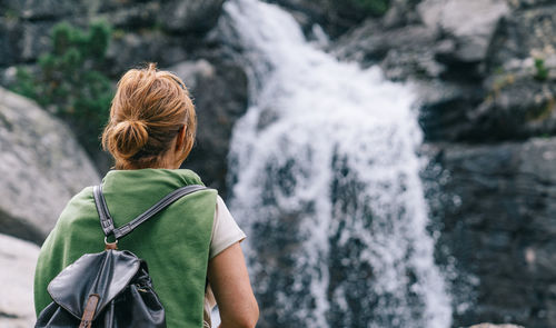 Rear view of woman looking at waterfall