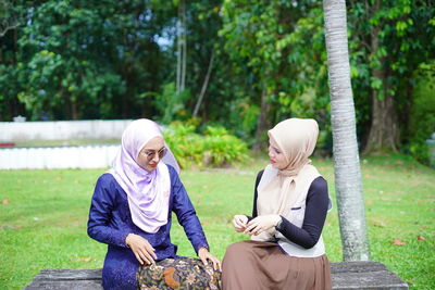 Woman sitting on bench in park