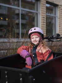 Smiling girl sitting in cargo bicycle