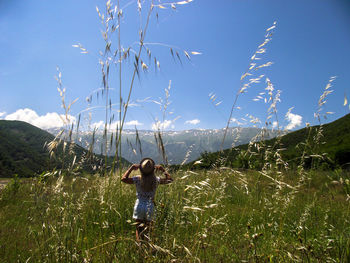 Full length of woman standing on field against sky