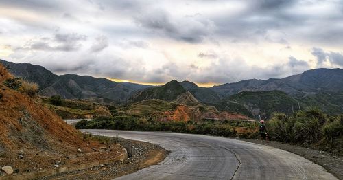 Road leading towards mountains against sky