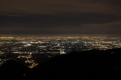 High angle view of illuminated buildings against sky at night