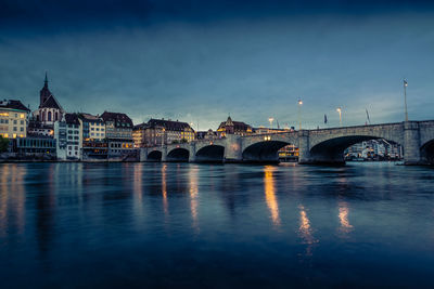 Arch bridge over river against sky at night