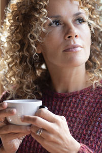 Portrait of young woman holding coffee