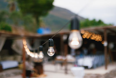 Close-up of illuminated light bulbs hanging from ceiling