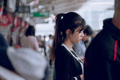 Woman standing at railroad station platform