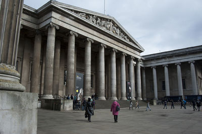 People walking in front of historical building