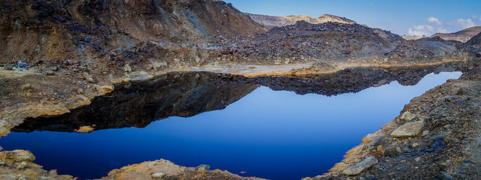 Scenic view of mountain against blue sky